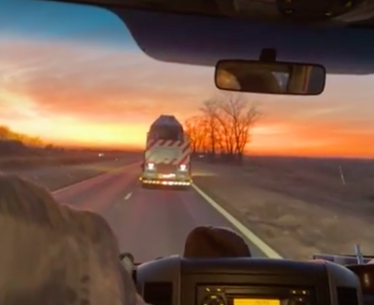 Looking out the front windshield of the transport van at the crate on the truck